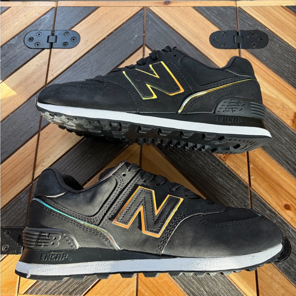 New Balance women’s 574 Sneakers in Black with Gold Highlights
